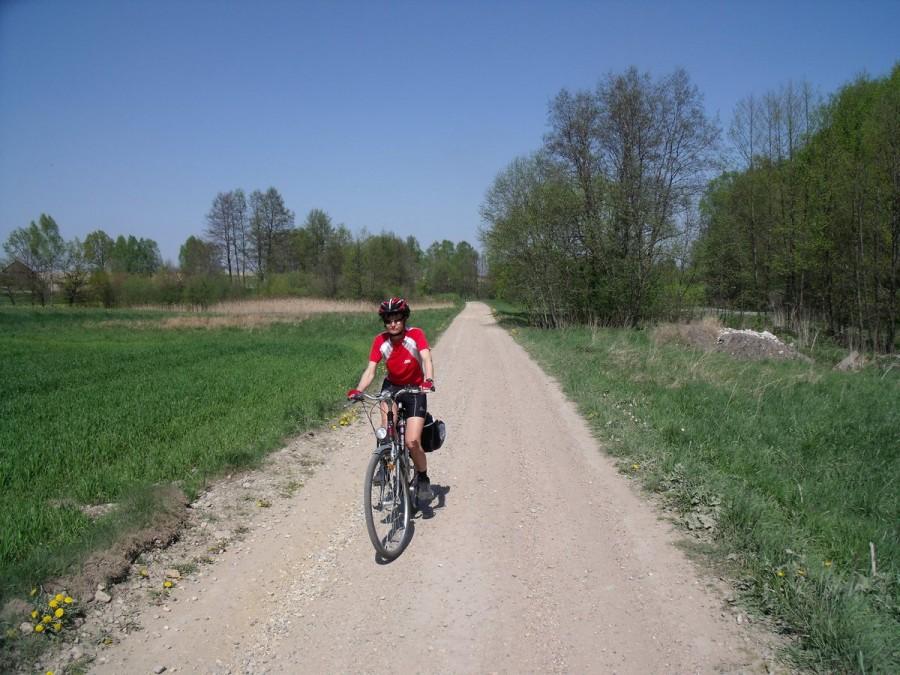 Rowerzysta na wiejskiej drodze w słoneczny dzień