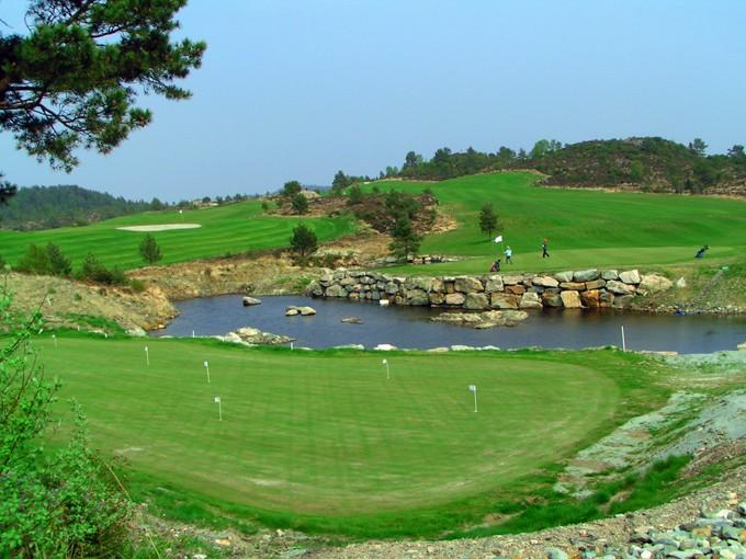 Pole golfowe z dołkiem, wodą i mostkiem
