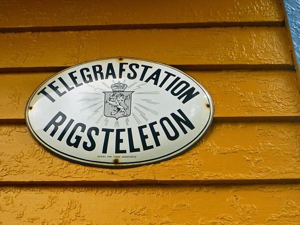 Wyjaśniać nie trzeba, emblemat na zabytkowej stacji telefonicznej.