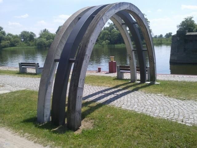Trzy łuki - drewniany, stalowy, betonowy symbolizujące historię mostu