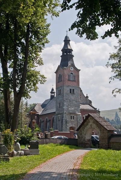 naprzeciwko drewnianego stoi solidniejszy, murowany