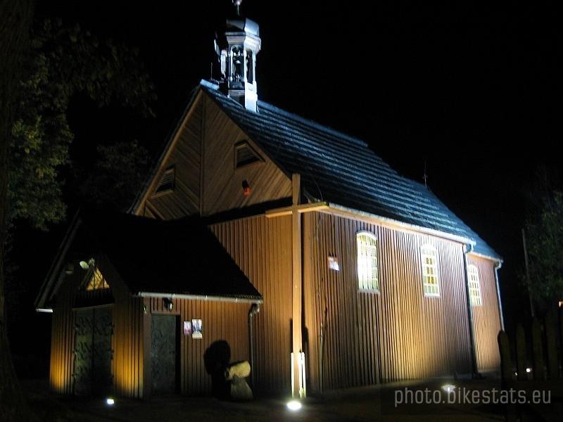 Drewniany kościółek w Węglewie w nocnej iluminacji.