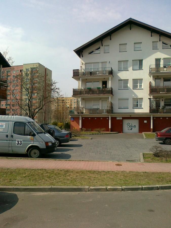 Nowe budynki na tle starych wieżowców