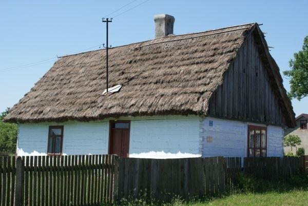 biała drewniana chałupinka kryta strzechą, w Potoku