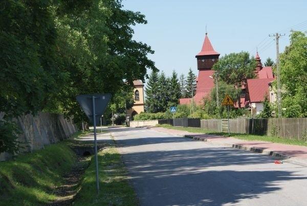 drewniany kościółek z czerwoną blachówką, w Zajączkowie