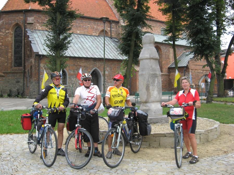 Konin- na tle kościoła Św. Bartłomieja a obok słupa z piaskowca uznanego za pierwszy w Polsce znak drogowy, który pokazywał połowę drogi pomiędzy Kaliszem i Kruszwicąą