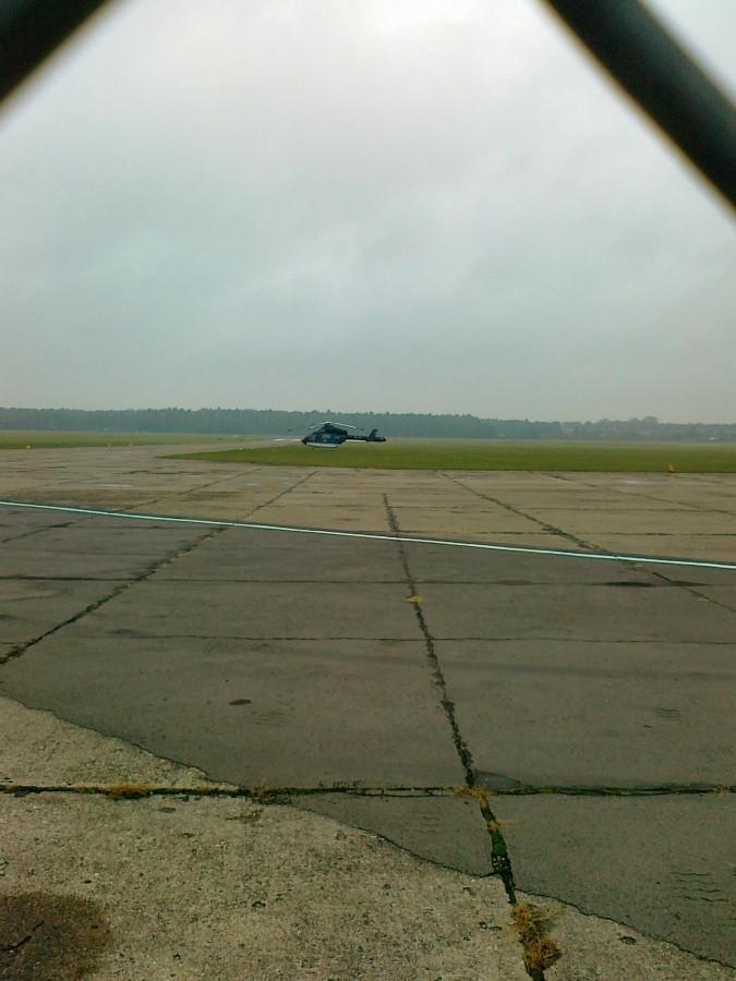 Płyta lotniska, w oddali helikopter