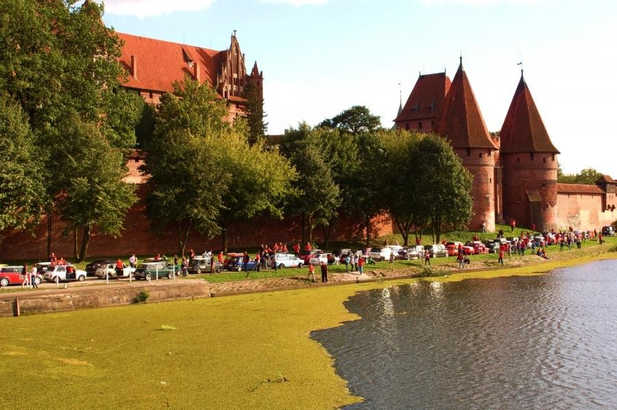 Wspólne zdjęcie miłośników aut mini na tle zamku