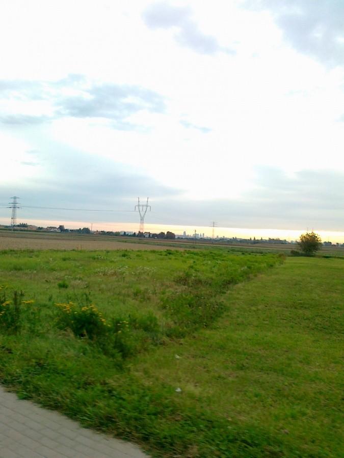 Łąki jeszcze całkiem zielone. Daleko na horyzoncie widać było PKiN