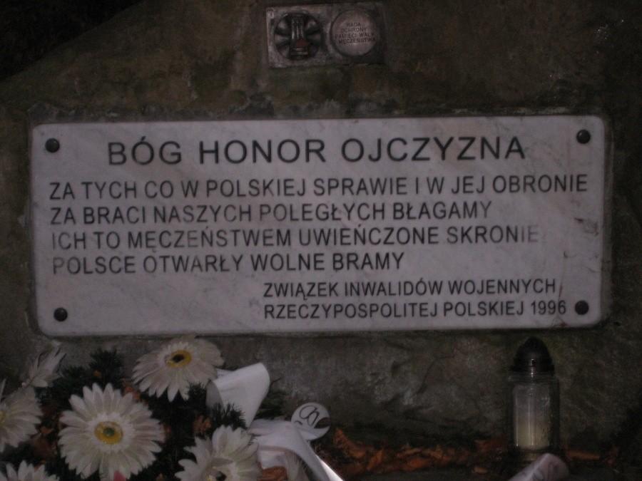 tablica u stóp krzyża stojącego opodal