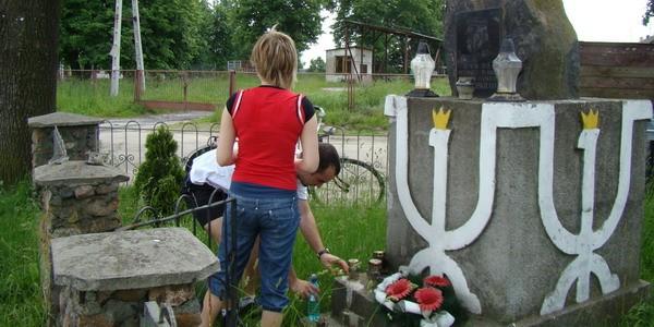 Zapalenie zniczy przy pomniku w Sitniku