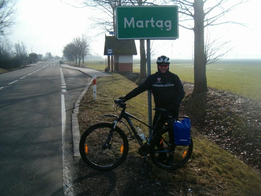 09-02-2013. Artur z rowerem przy drodze we wsi Martąg.