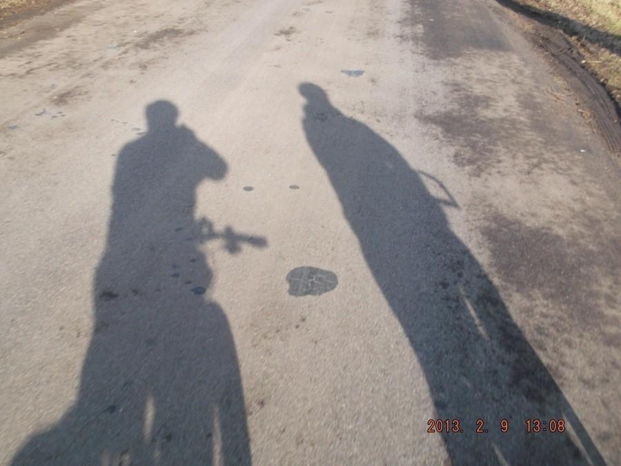 09-02-2013. Dwa cienie rowerzystów odbijające się na nawierzchni drogi.