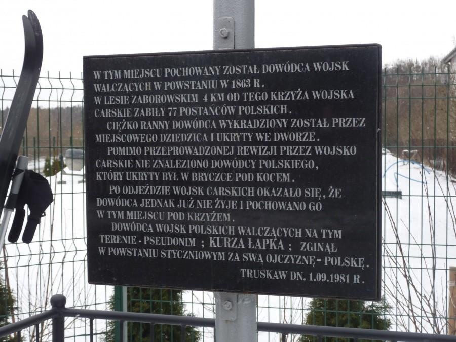 Tablica na krzyżu pw Truskawiu. Krzyż upamiętnia miejsce pochówku dowódcy wojsk walczących w powstaniu styczniowym w 1863 roku w lesie pod Zaborowem
