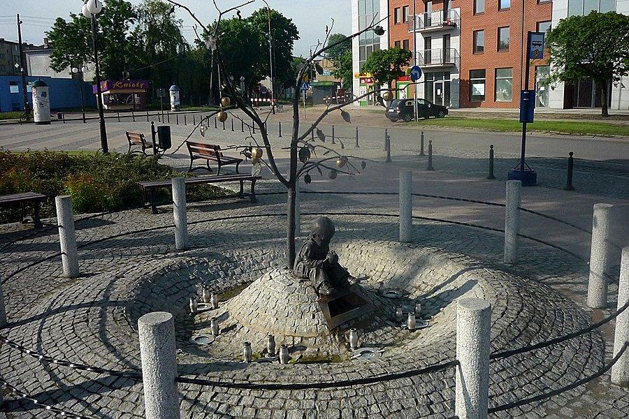 Chłopiec z jabłkiem przed dworcem w Skierniewicach