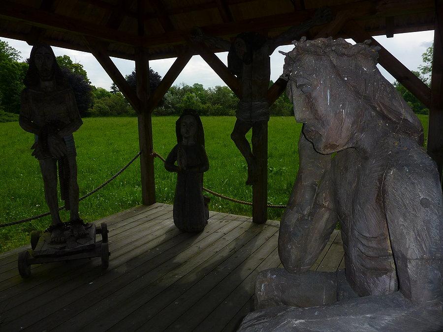 Rzeźby ze spektaklu Kazimierza Dejmka "Gra o Narodzeniu i Męce" upamiętniające lokalizację drewnianego kościoła