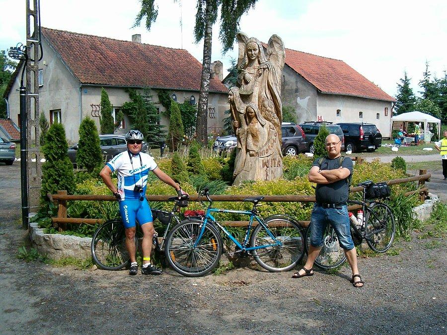 29-06-2013. Zdjęcie przedstawia rowerzystów po lewej Artura i po prawej Piotra przy pomniku rzeźbie aniołów we wsi Aniołowo
