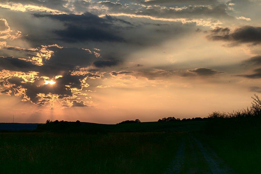 Scłońce za chmurami coraz niżej schodziło