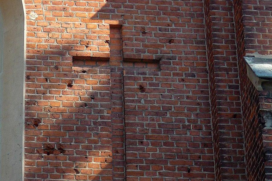 Ślady po ostrzlale z czasów II wojny na murze kościoła w Kompinie