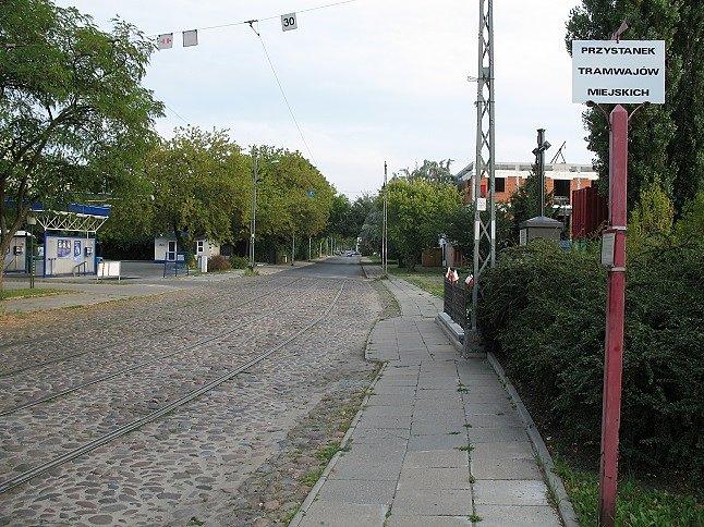 Ulica Wysockiego - Fragment starefo torowiska w bruku miejskim z zachowanymi słupami trakcyjnymi i przystankiem - okolice pętli tramwajowej na Pelcowiźnie