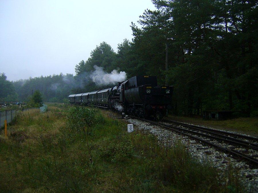 Ty42-107 z pociągiem retro zbliża się do stacji kolejowej w Spale