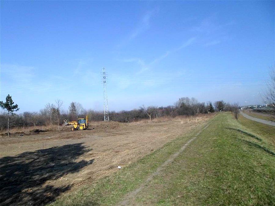 Żółty spychacz przy trasie Mostu Siekierkowskiego