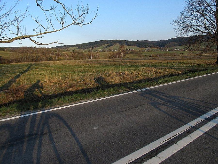 Cień pleców na asfalcie z górami w tle