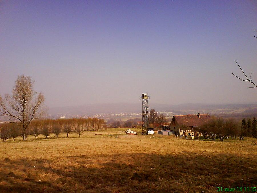 Widok na wieś Jasna Góra. Na pierwszym planie przyzagrodowa wieża widokowa, a na trzecim Bogatynia i zapylenie atmosfery