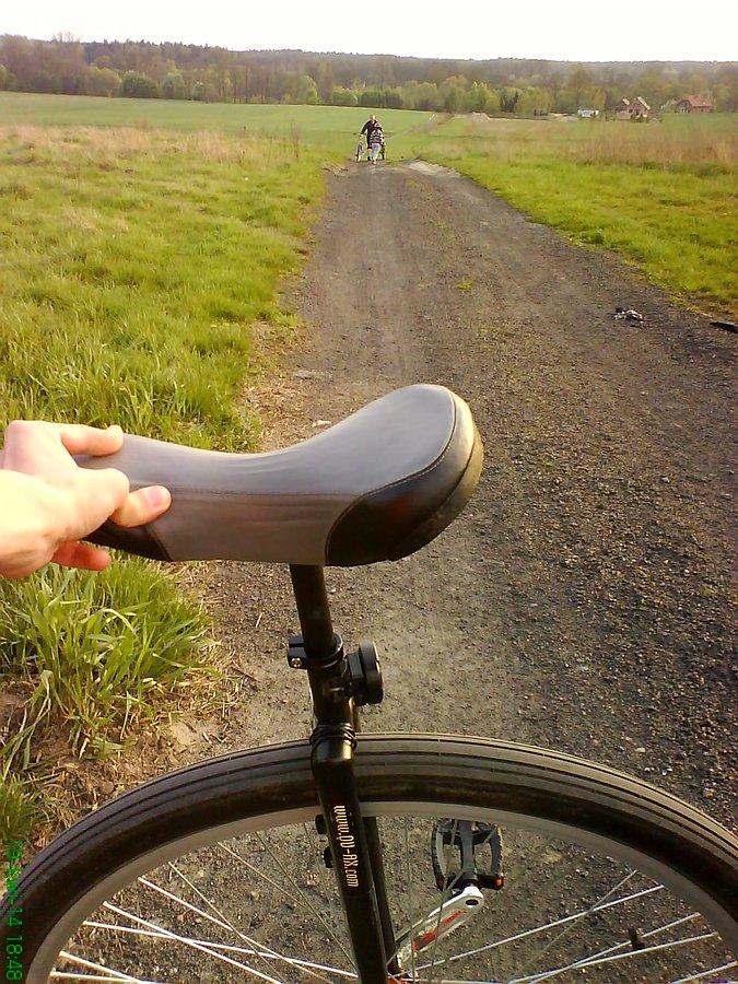 Szczegóły, których nie widać: ludzie w tle wprowadzają rowery po stromym podjeździe pod wiatr. A wielkie, 36" mono wjechało