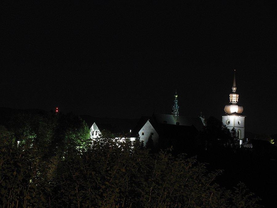 Zabytkowy Stary Sącz z świecącą na czerwono Przehybą w tle
