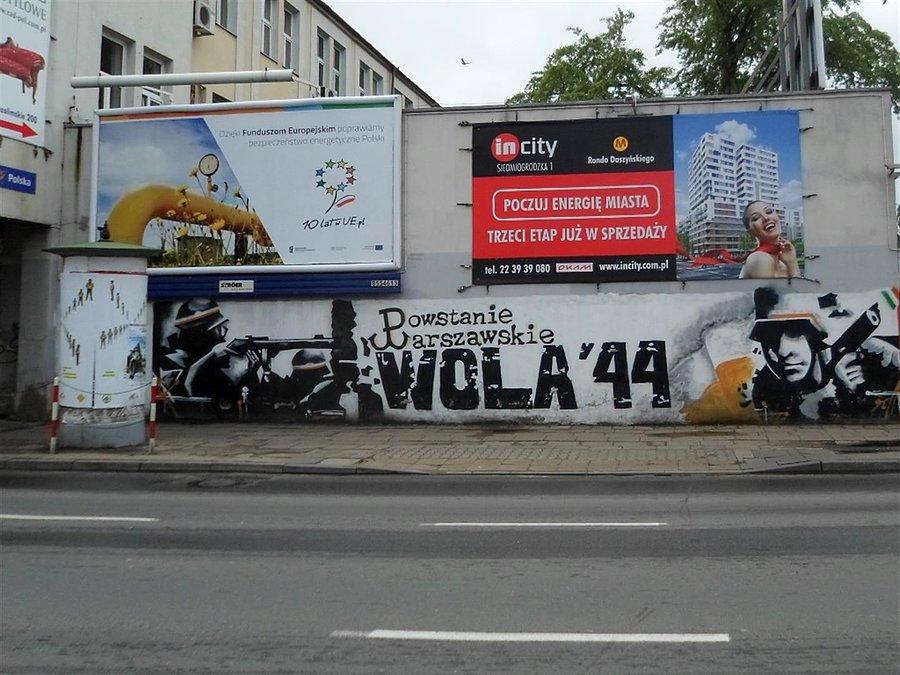 Mural Powstanie Warszawskie, a nad nim łączniczka albo sanitariuszka
