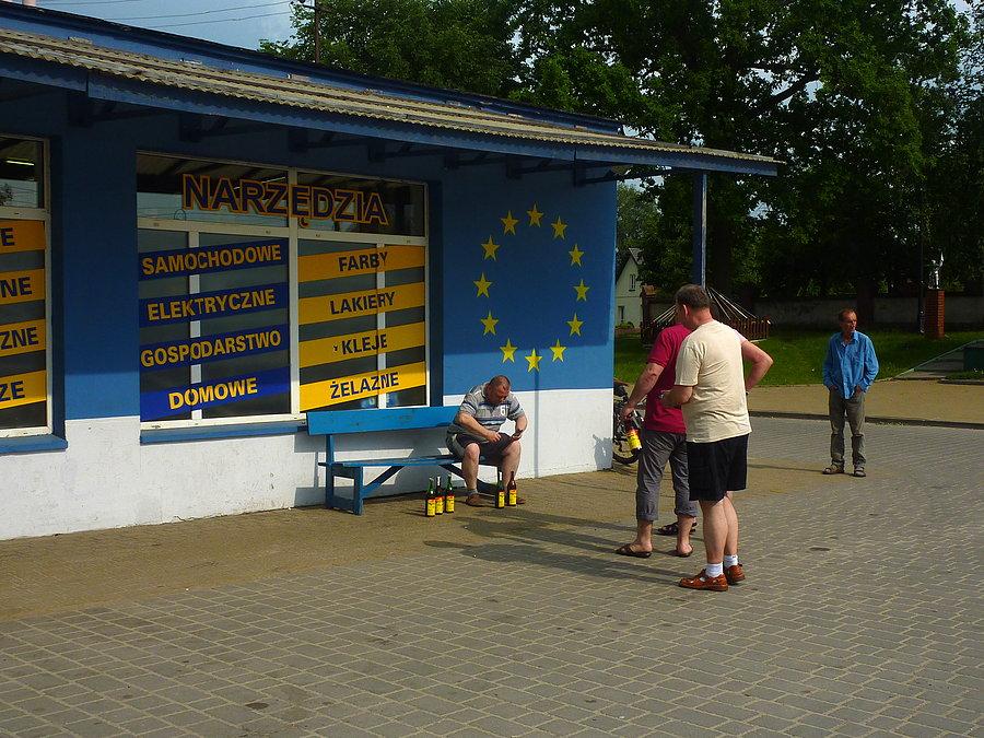 A pod sklepem mnóstwo osób robiących sobie zdjecia z "miejscowym przysmakiem" (Mamrot - 5zł). Dużo pozowania i wymieniania się aparatami. Każdy chce mieć zdjęcie na ławeczce