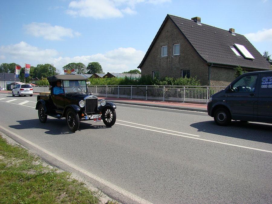 Sternfahrt 2014 kawalkadę rowerzystów stojących na stacji paliw mija kawalkada ... starych zabytkowych aut. 2