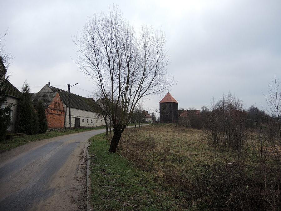 Radosiew - widok na zabytkową drewnianą dzwonnicę w centrum wsi