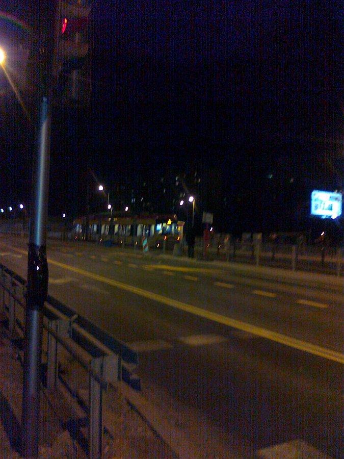 Tramwaj 11 na przystanku przy Kazubów słabo widoczny po ciemku
