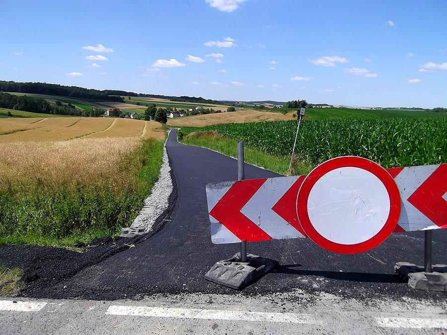 Wylewają asfalt na szutrowej drodze do Owsiszcz