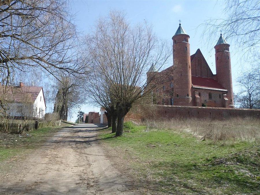 Droga polna z kościołem obronnym w tle