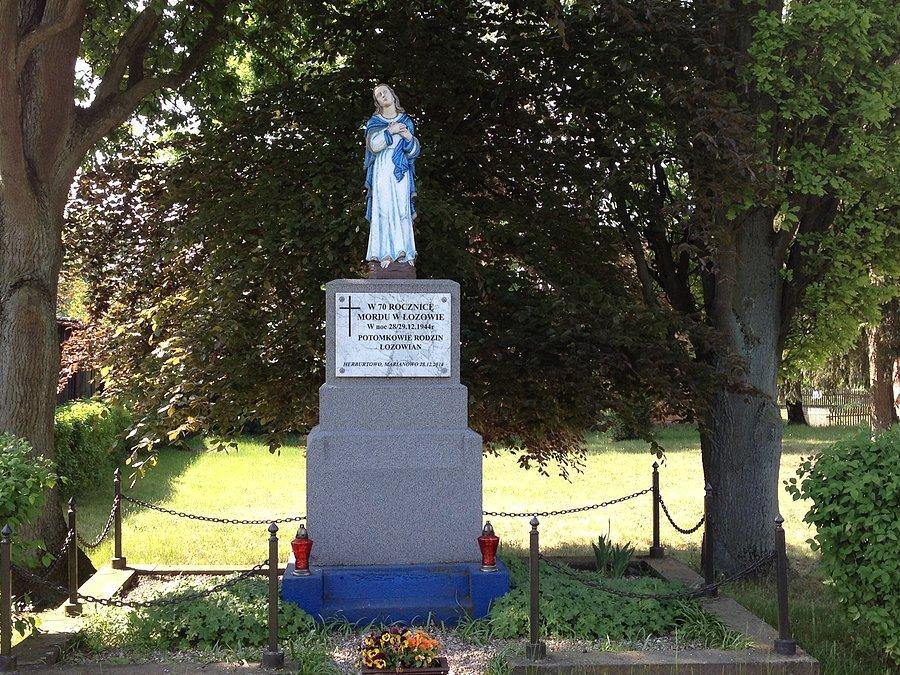 Kapliczka przy kościele w Herburtowie z tablicą upamiętniająca 70 rocznicę mordu w Łozowie