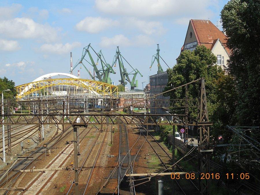 Z wiaduktu nad linia kolejową w ciągu Alei Zwycięstwa widać żurawie portu w Gdańsku