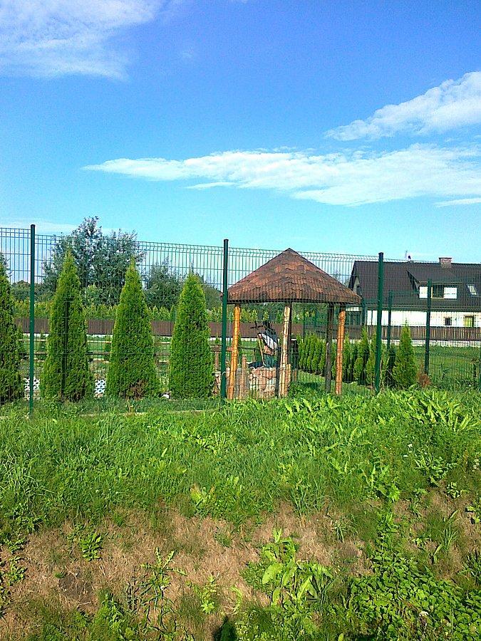 Pod wiatą figurka Chrystusa, chyba frasobliwego, ale nie widać, bo siedzi tyłem do drogi