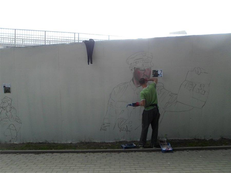 Autor Jarek Fabiś przy pracy - mural trasa AK