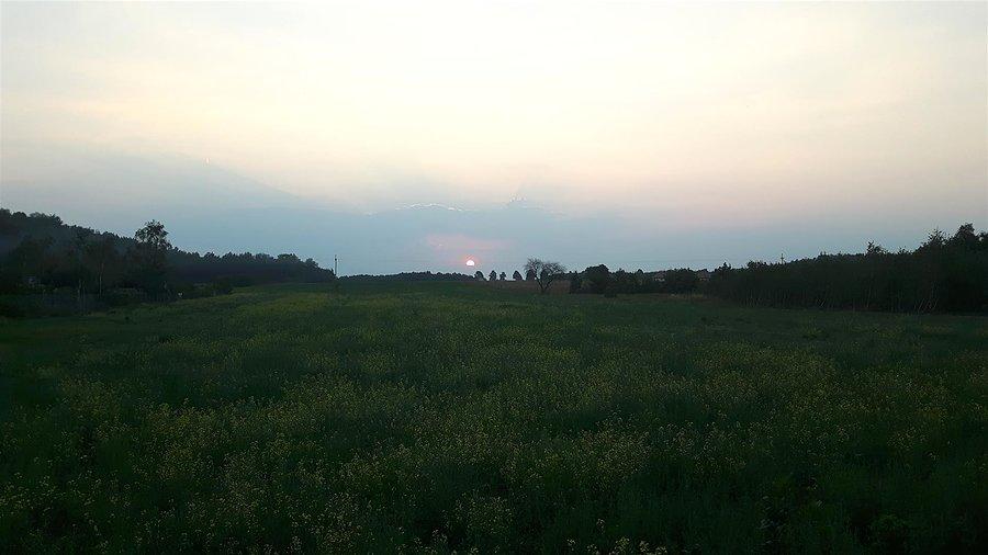 Zachodzące słońce nad polami w Błędowie o 18:46