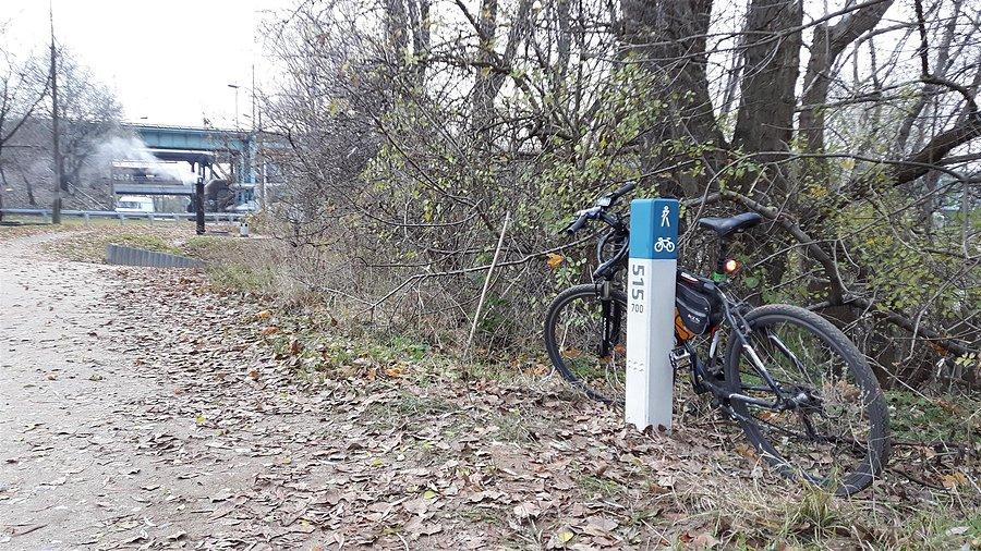 Rowerowy słupek kilometrowy w tle Most Gdański