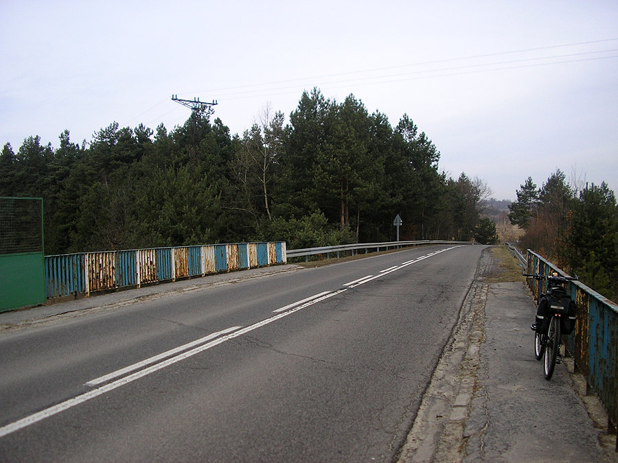 Charakterystyczny, pordzewiały wiadukt nad linią kolejową