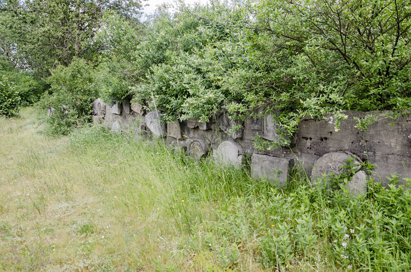 Połamane macewy wkomponowane w mur