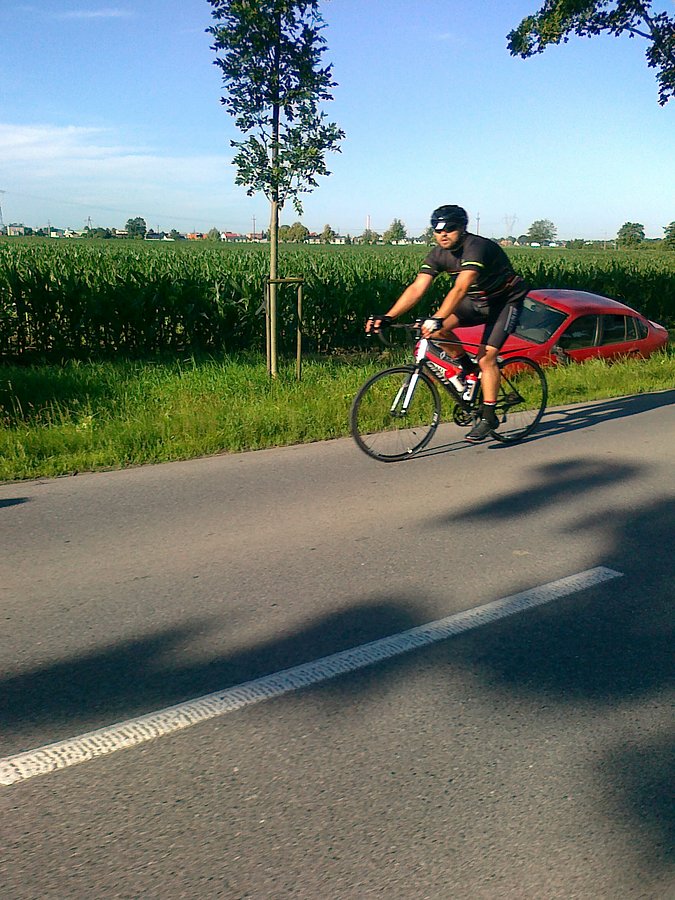 Kolarz i auto w rowie