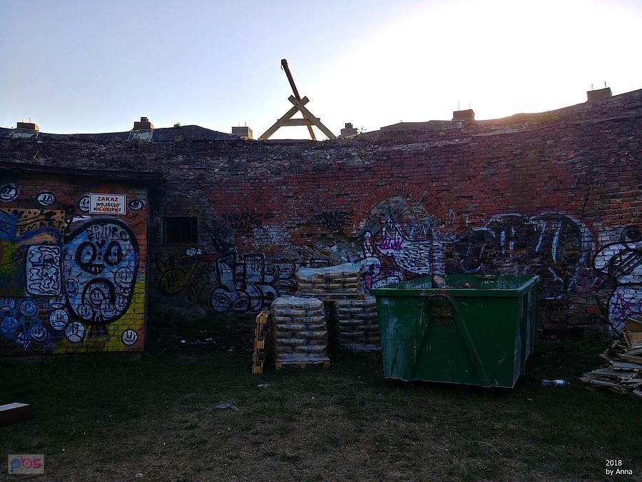 Mur z graffiti i składowisko odpadów budowlanych