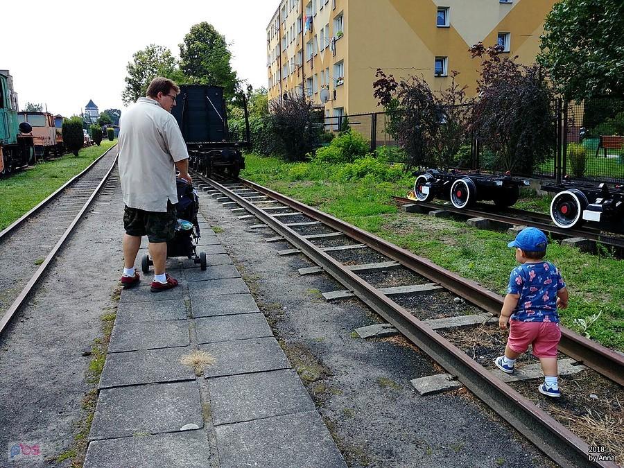 Rodzina na stacji kolejowej z zabytkowymi wagonami