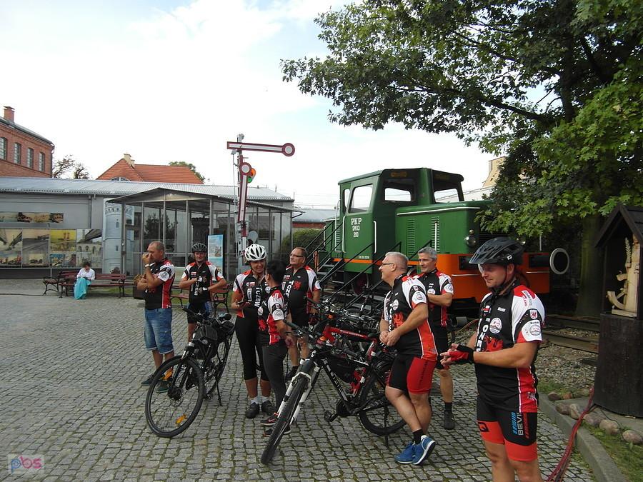 Grupa rowerzystów przy zabytkowym pociągu