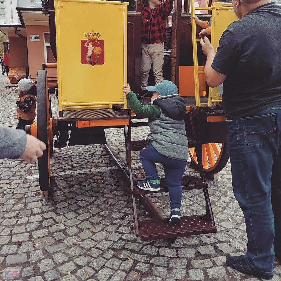 Dziecko wsiada na żółty tramwaj